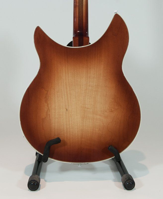 The back of a guitar is shown on a stand