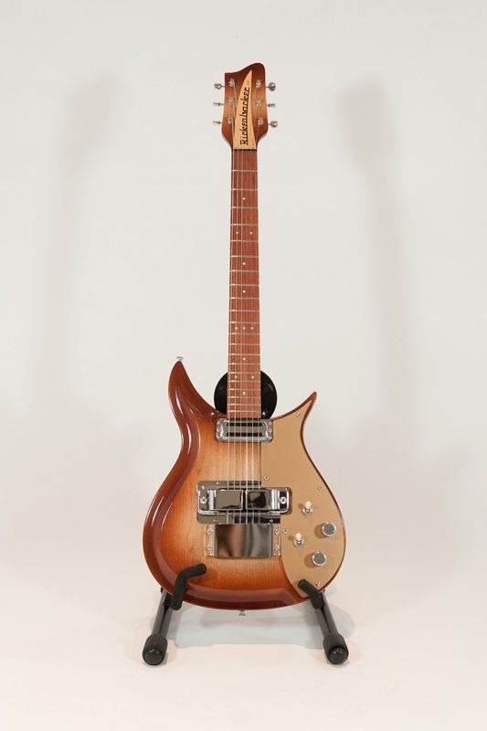 A guitar is sitting on a stand on a white background.