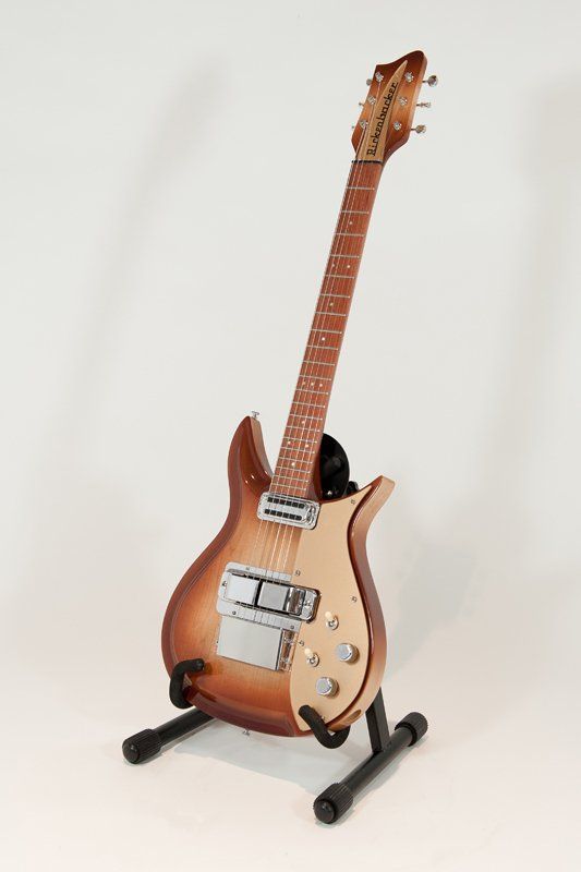 A guitar is sitting on a stand on a white background.