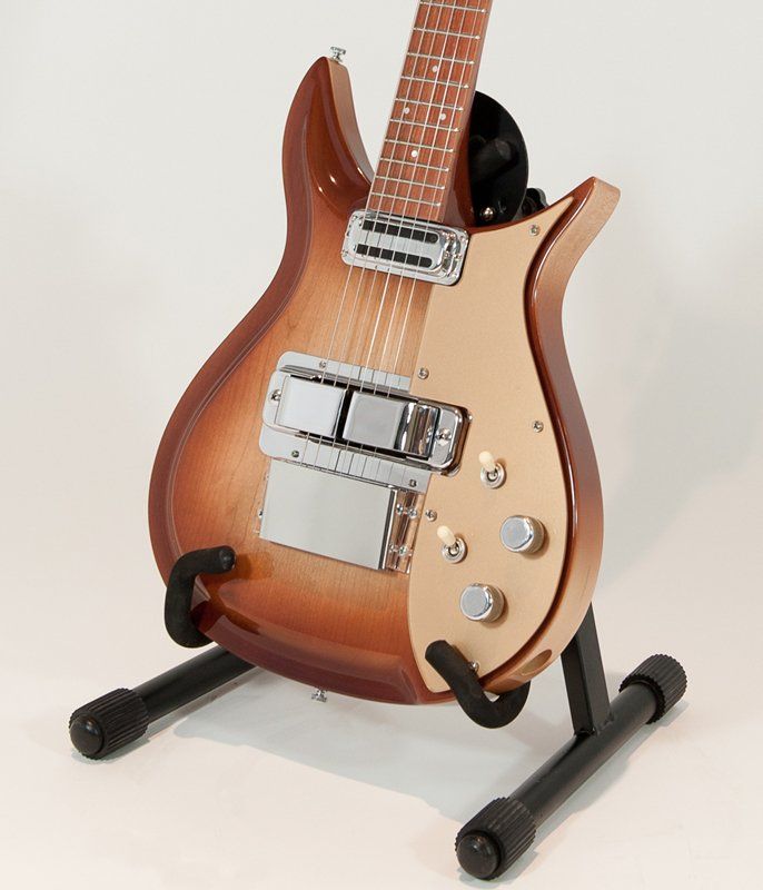 A guitar is sitting on a stand against a white background