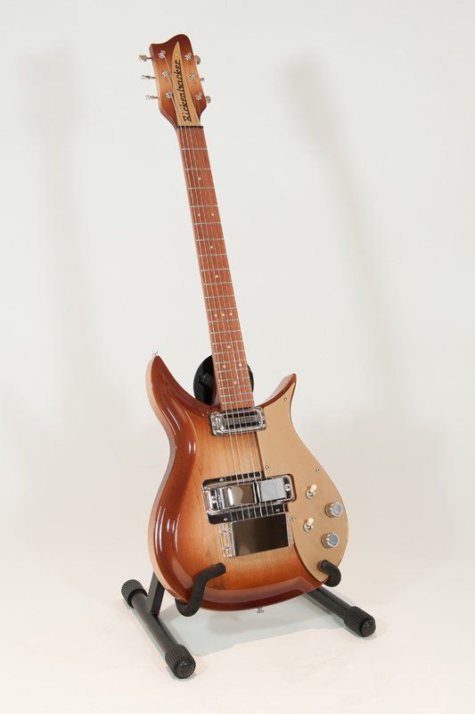 A guitar is sitting on a stand on a white background.