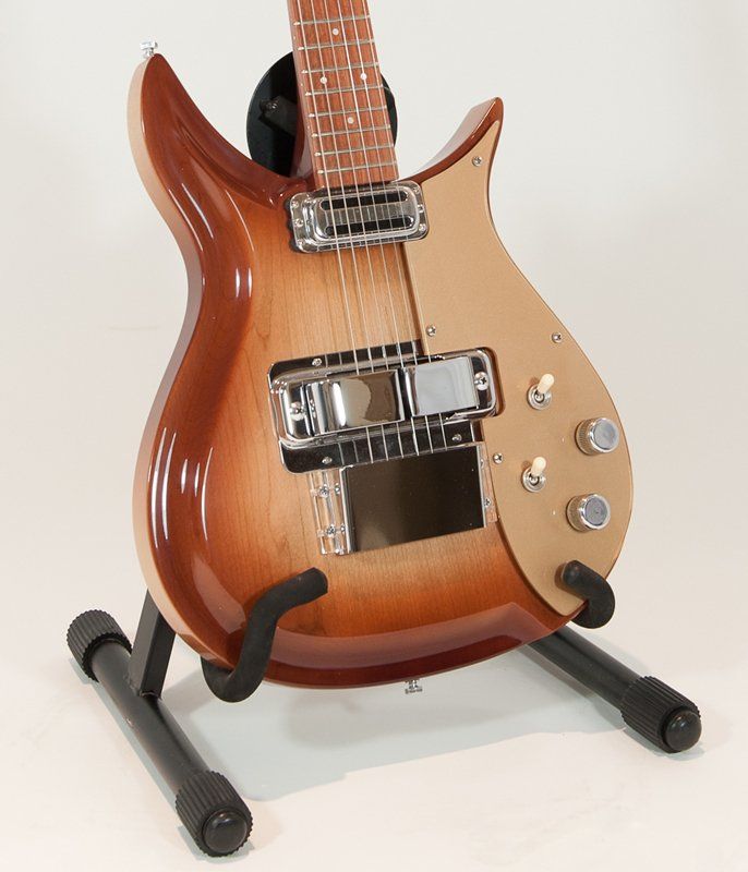 A guitar is sitting on a stand on a white surface