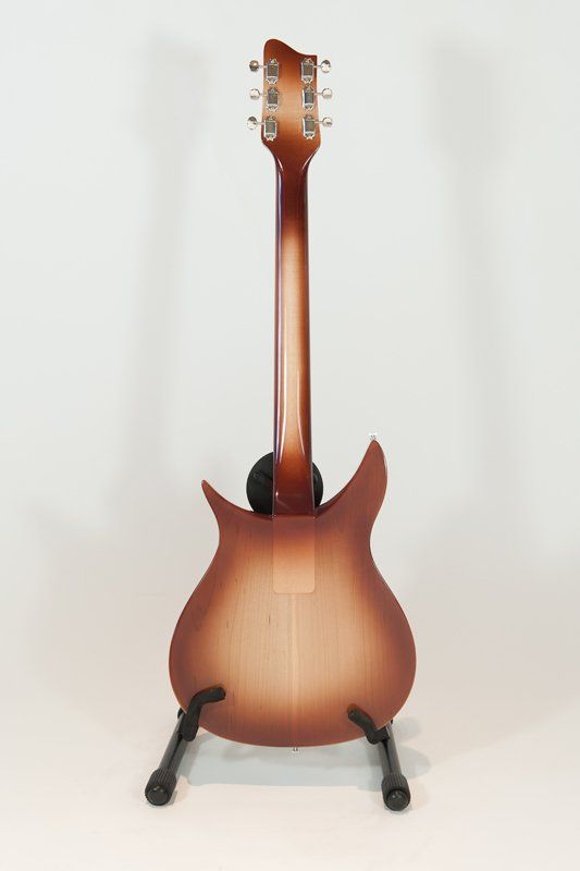 The back of a guitar is shown on a stand.
