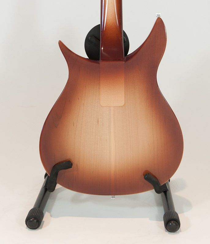 A guitar is sitting on a stand on a white surface