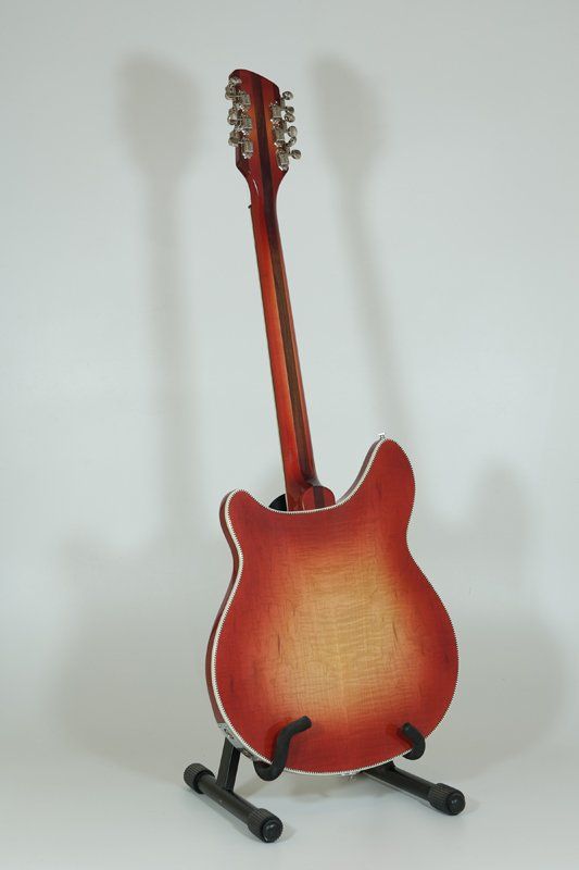A red electric guitar is sitting on a stand