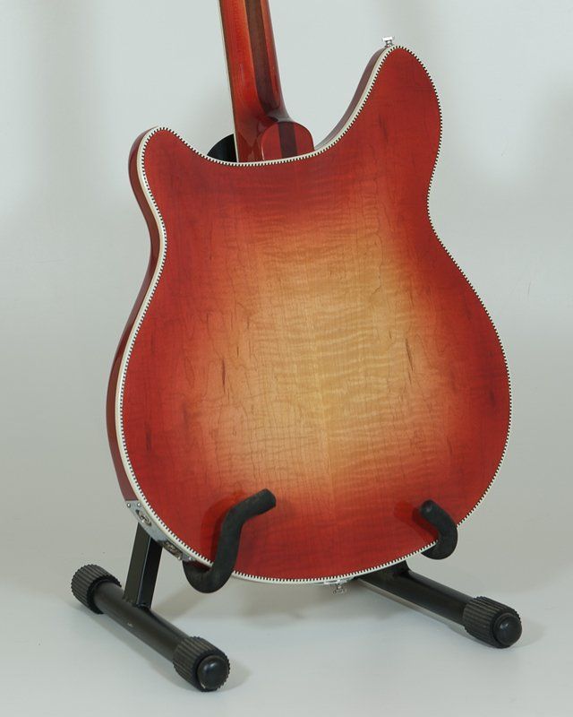 The back of a red guitar on a stand