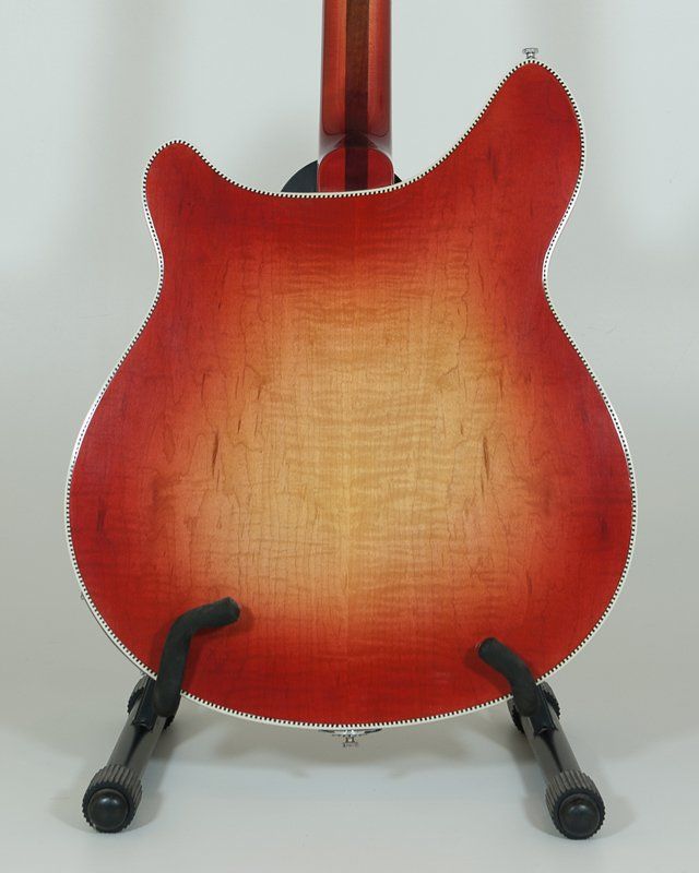 A red guitar is on display on a stand