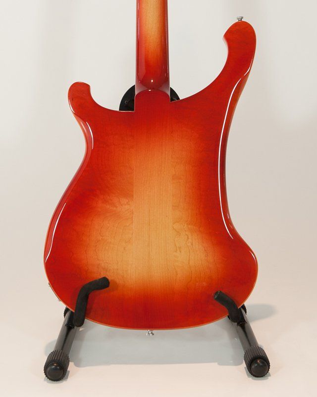 A red electric guitar is sitting on a stand