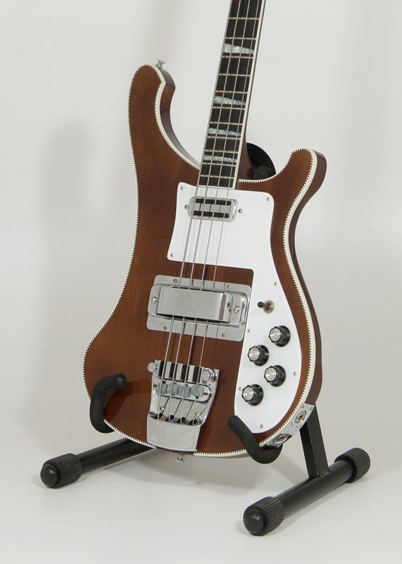 A brown and white bass guitar on a stand