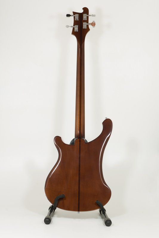 The back of a bass guitar is shown on a stand