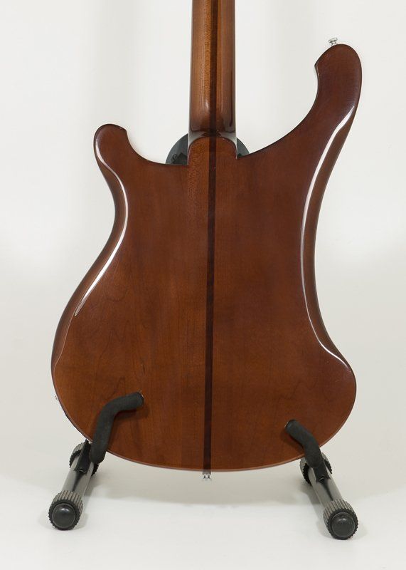The back of a guitar is shown on a stand