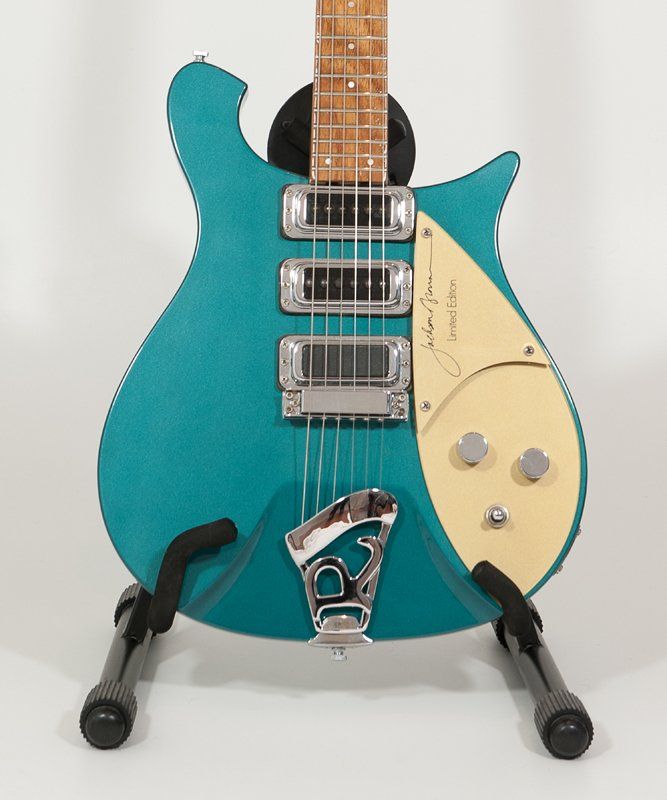 A blue electric guitar is sitting on a stand