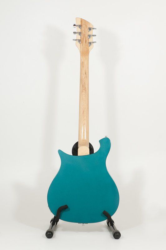 A blue guitar is sitting on a stand on a white background