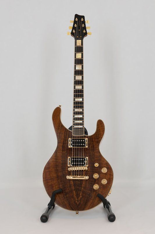 An electric guitar is sitting on a stand on a white background.