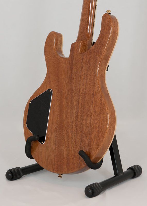 The back of a guitar is shown on a stand