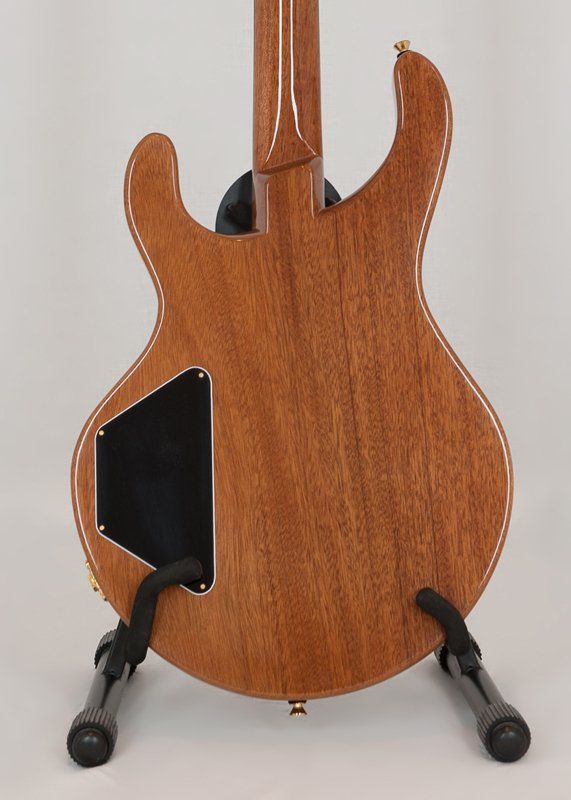 The back of a guitar is shown on a stand