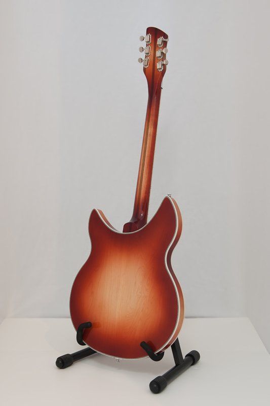 A guitar is sitting on a stand on a table