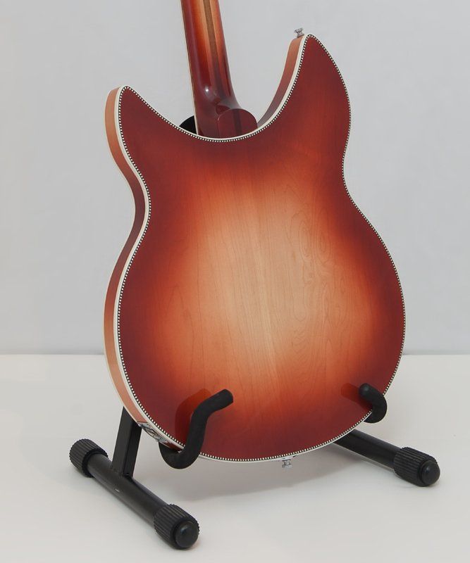 The back of a guitar is shown on a stand