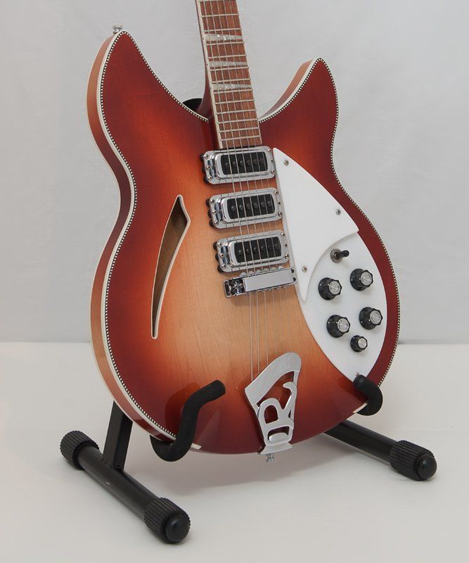 A rickenbacker guitar is sitting on a stand