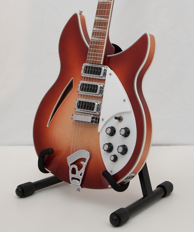 A guitar is sitting on a stand that says ' rickenbacker ' on it