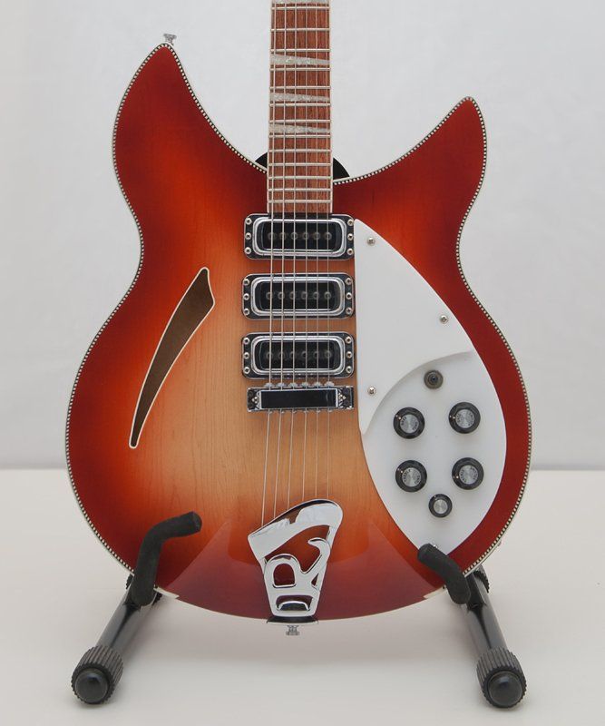 A rickenbacker guitar is sitting on a stand