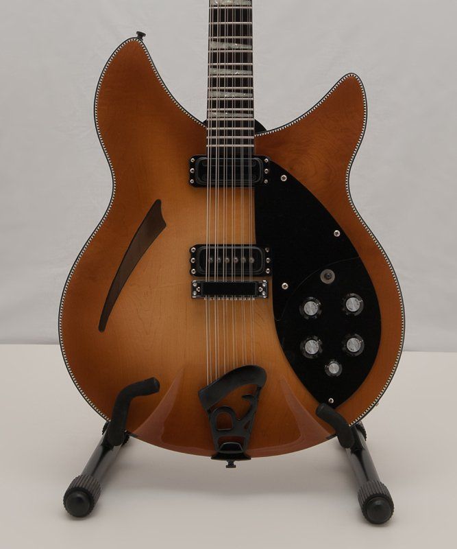 A brown and black guitar is sitting on a stand