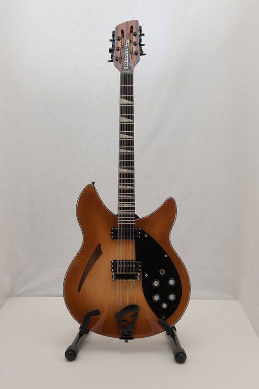 A guitar is sitting on a stand on a table