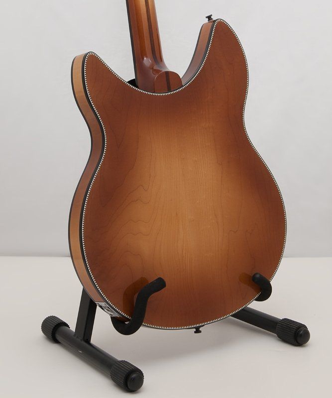 The back of a guitar sitting on a stand