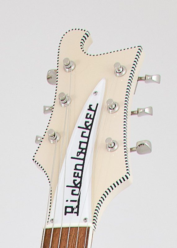 The headstock of a white rickenbacker electric guitar