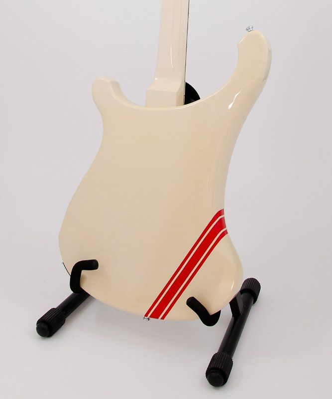 A white guitar with a red stripe on the back is on a stand
