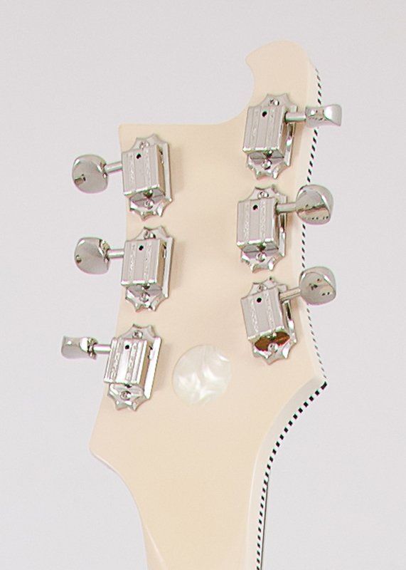 A close up of the headstock of a white electric guitar