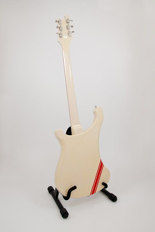A white electric guitar is sitting on a black stand