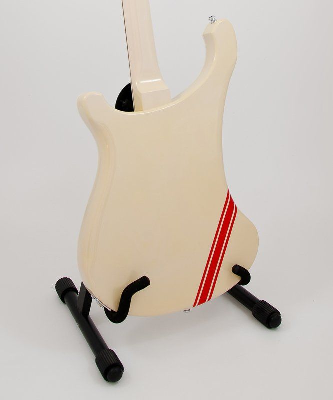 A white guitar with a red stripe on the back sits on a stand