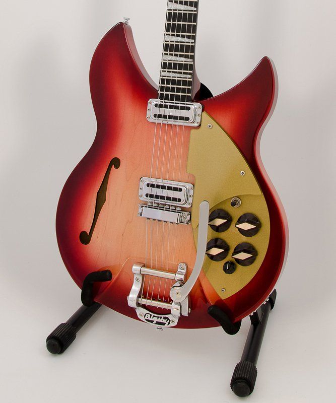 A red and yellow guitar is sitting on a stand