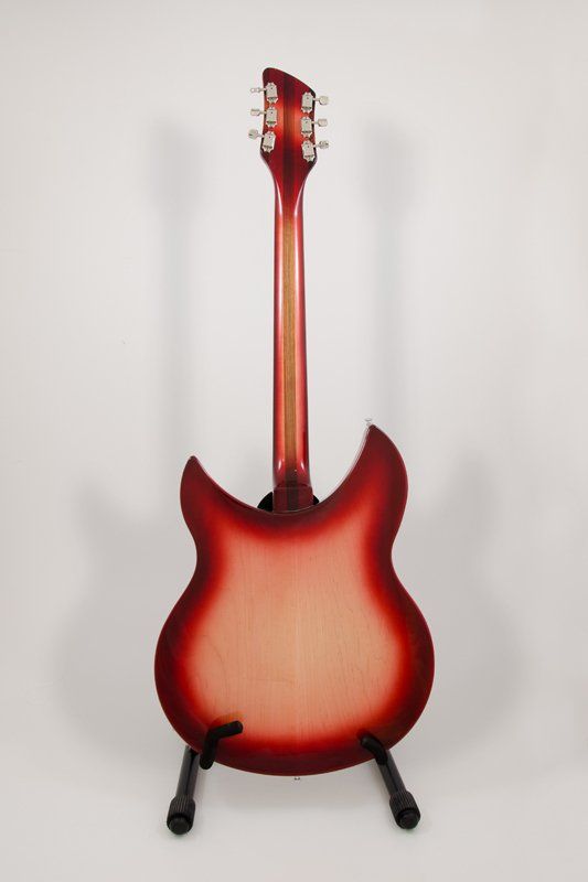 A red electric guitar is sitting on a stand