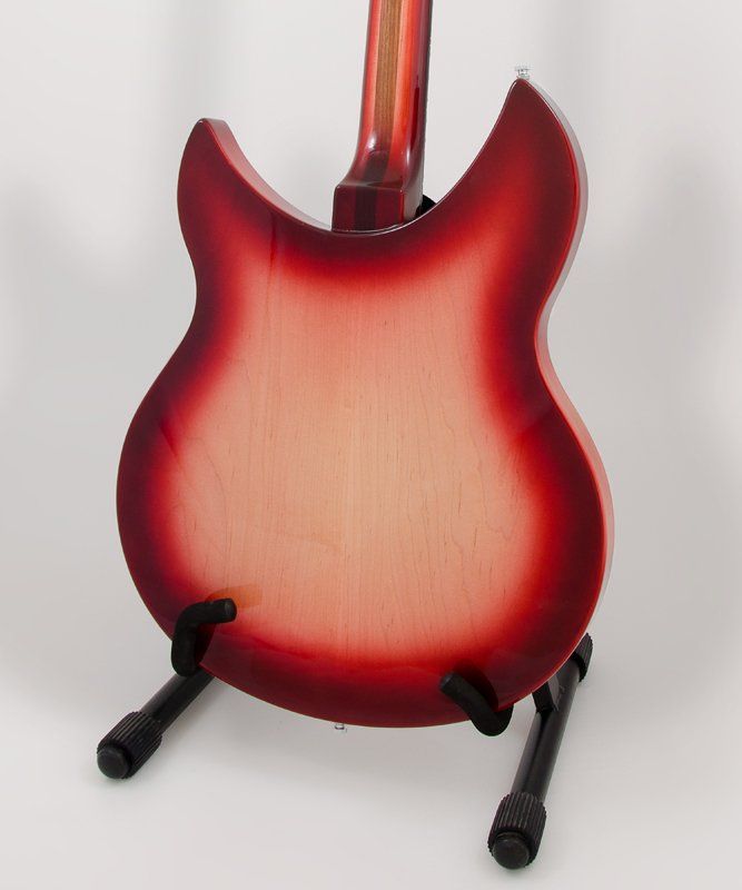 A red electric guitar is sitting on a stand