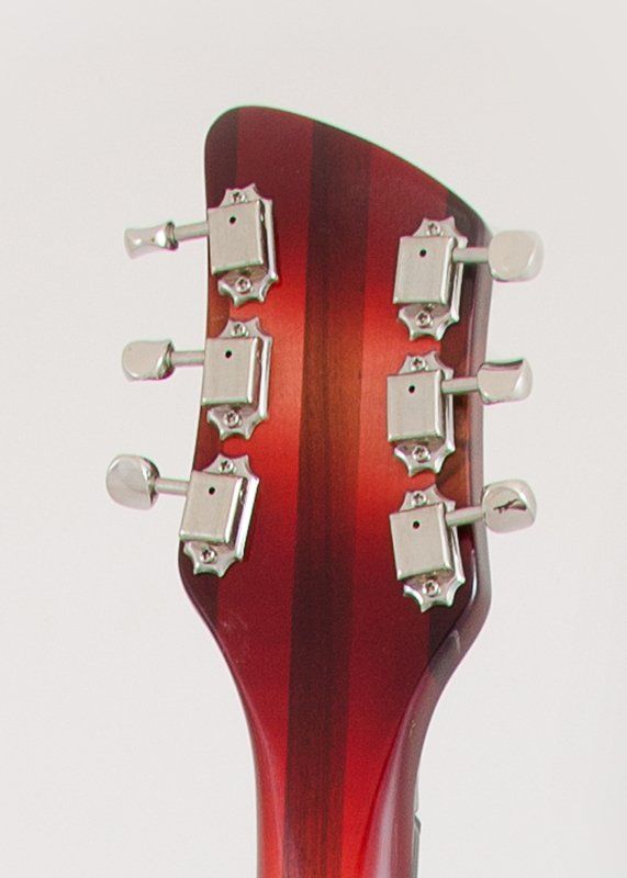 A close up of the headstock of a red guitar