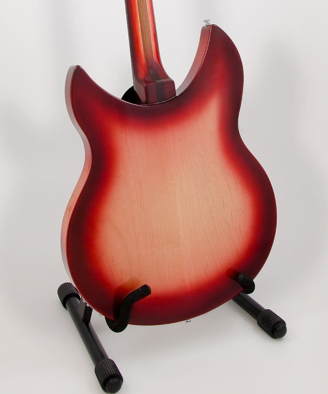 A red guitar is sitting on a black stand
