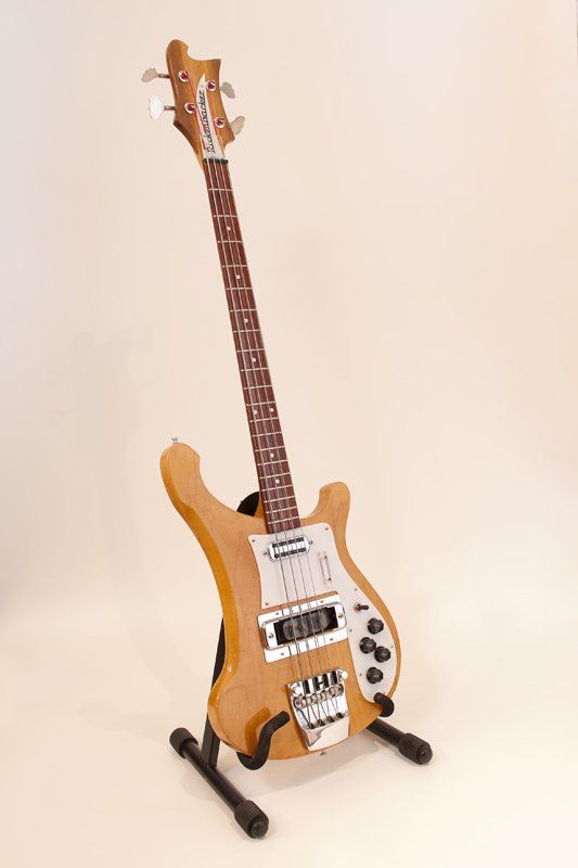 A guitar is sitting on a stand on a white background.