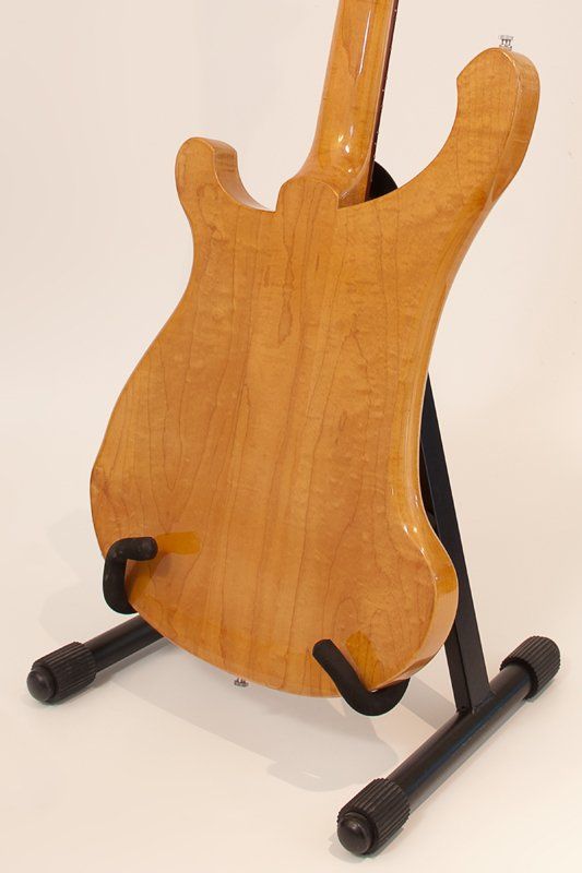 The back of a guitar is shown on a stand