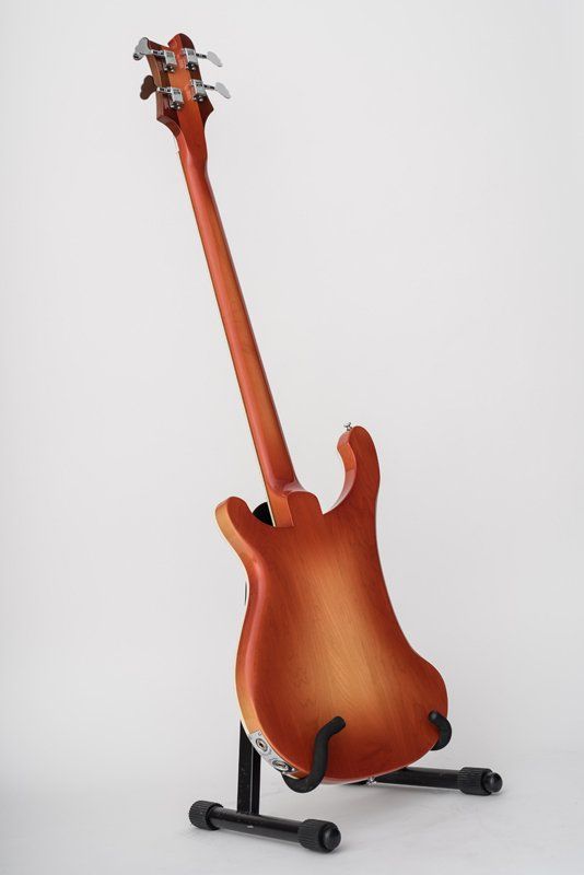 A guitar is sitting on a stand on a white background.