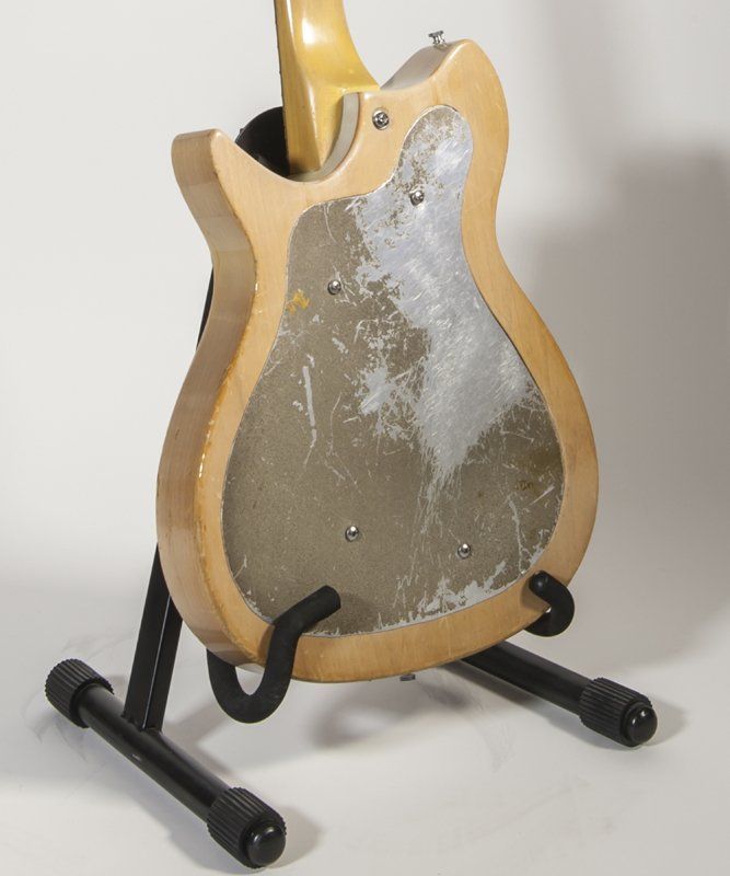 A guitar is sitting on a stand against a white background