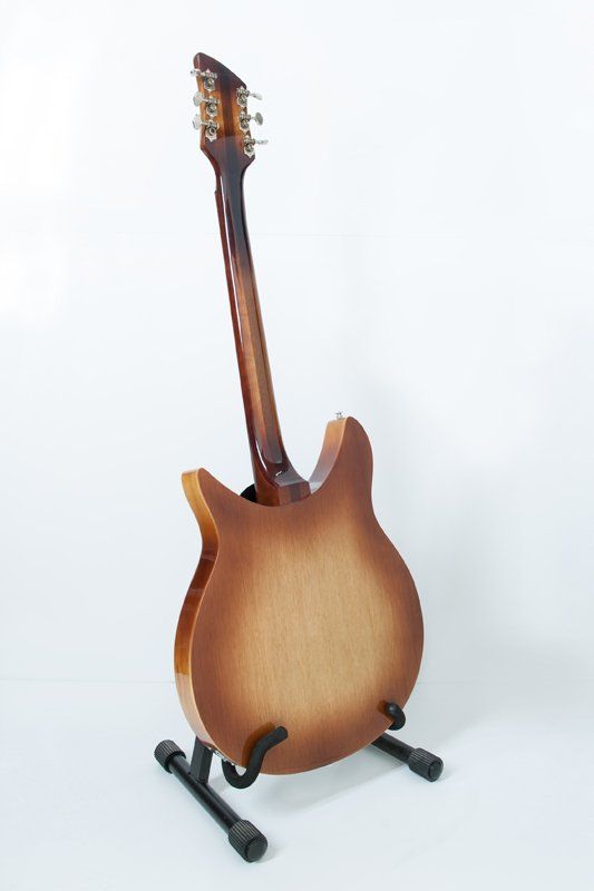 A guitar is sitting on a stand on a white background.
