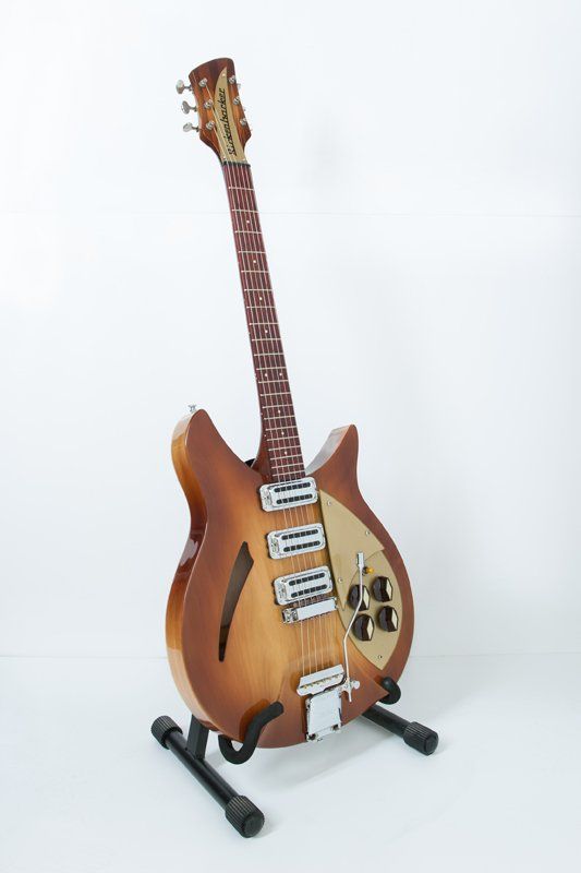 A guitar is sitting on a stand on a white background