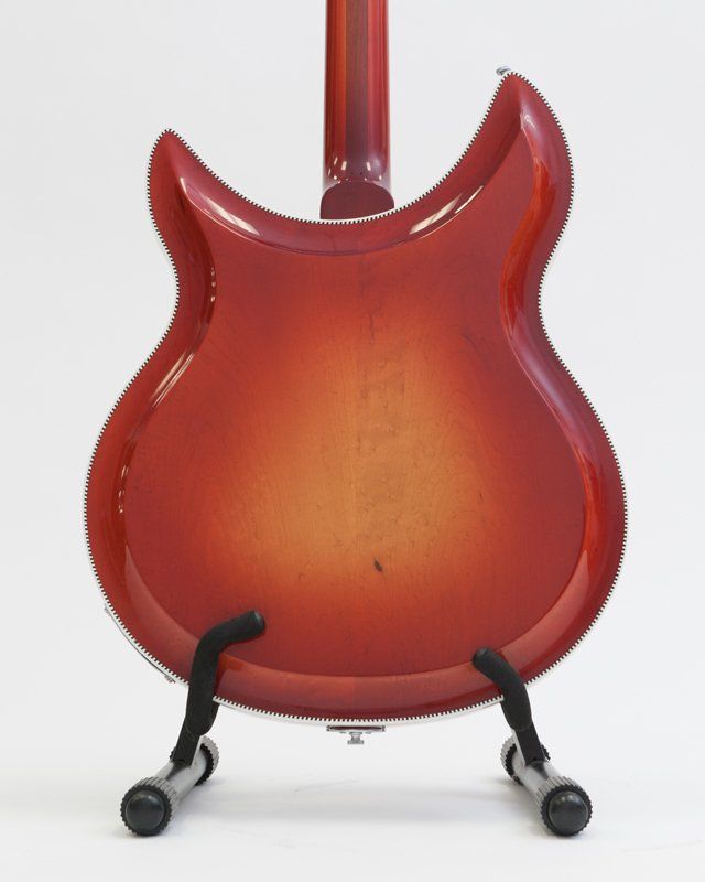 The back of a red guitar on a stand