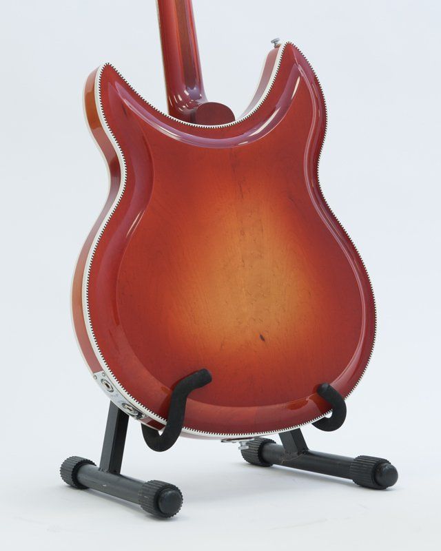 The back of a red guitar on a stand