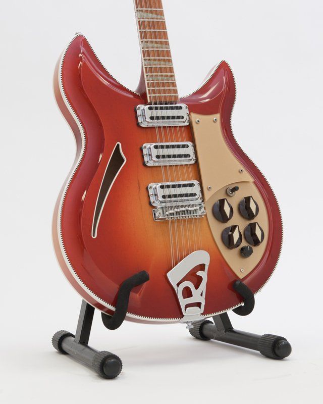 A rickenbacker guitar is on display on a stand