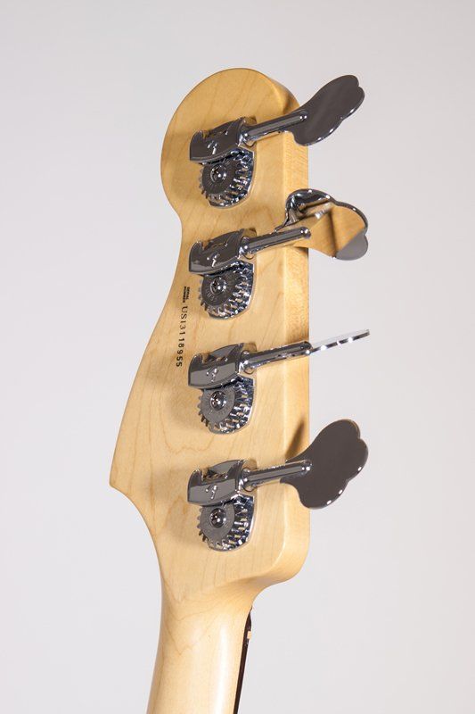 A close up of the headstock of a bass guitar on a white background.