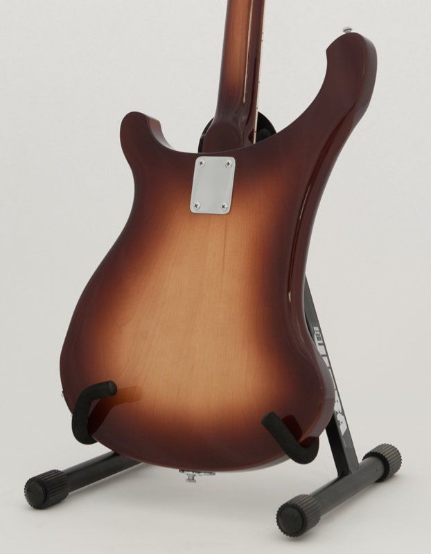 The back of a guitar is shown on a stand