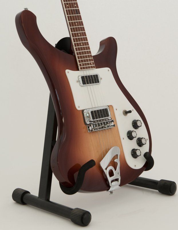 A guitar on a stand with the letter p on it